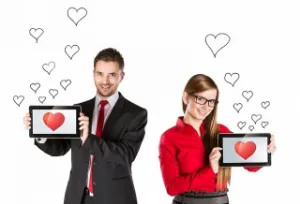 парень и девушка держат планшеты с сердечком