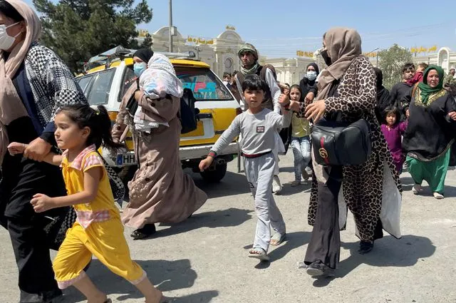 Женщины с детьми пытаются попасть внутрь международного аэропорта им. Хамида Карзая в Кабуле.