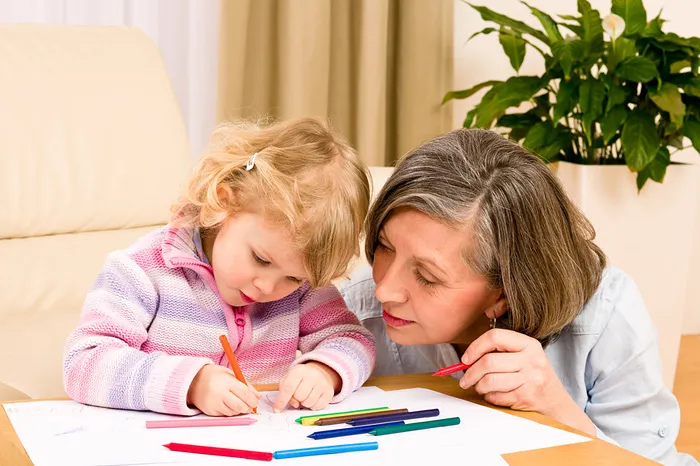 Бабушка помогает внучке рисовать